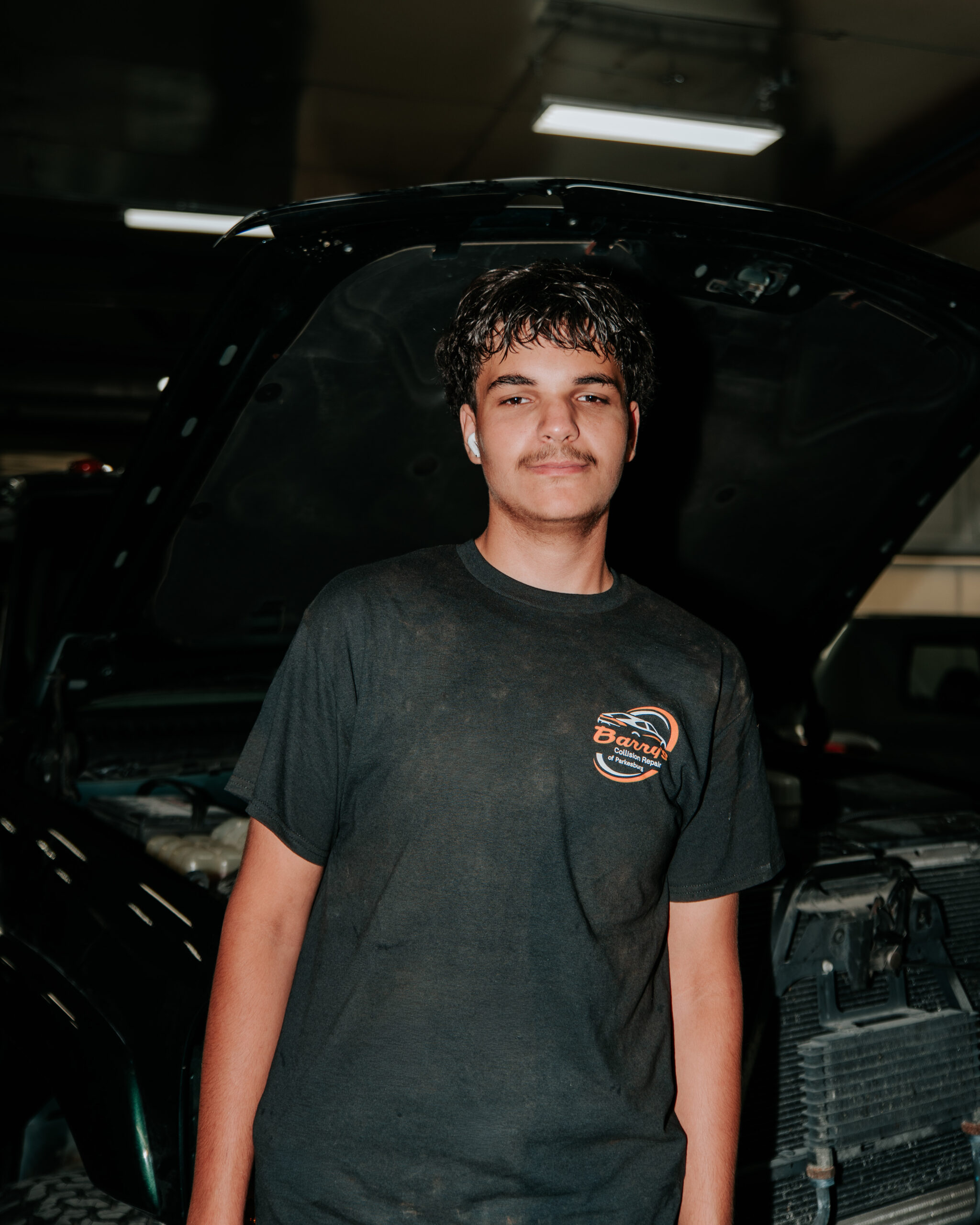 Barry's Collision Repair technician, Nate, in auto shop environment.